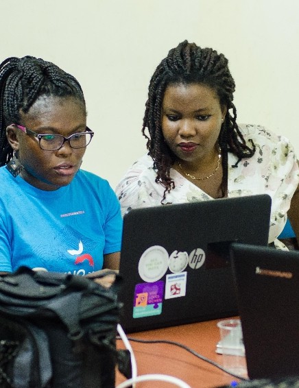Two women working together at a laptop during a training session